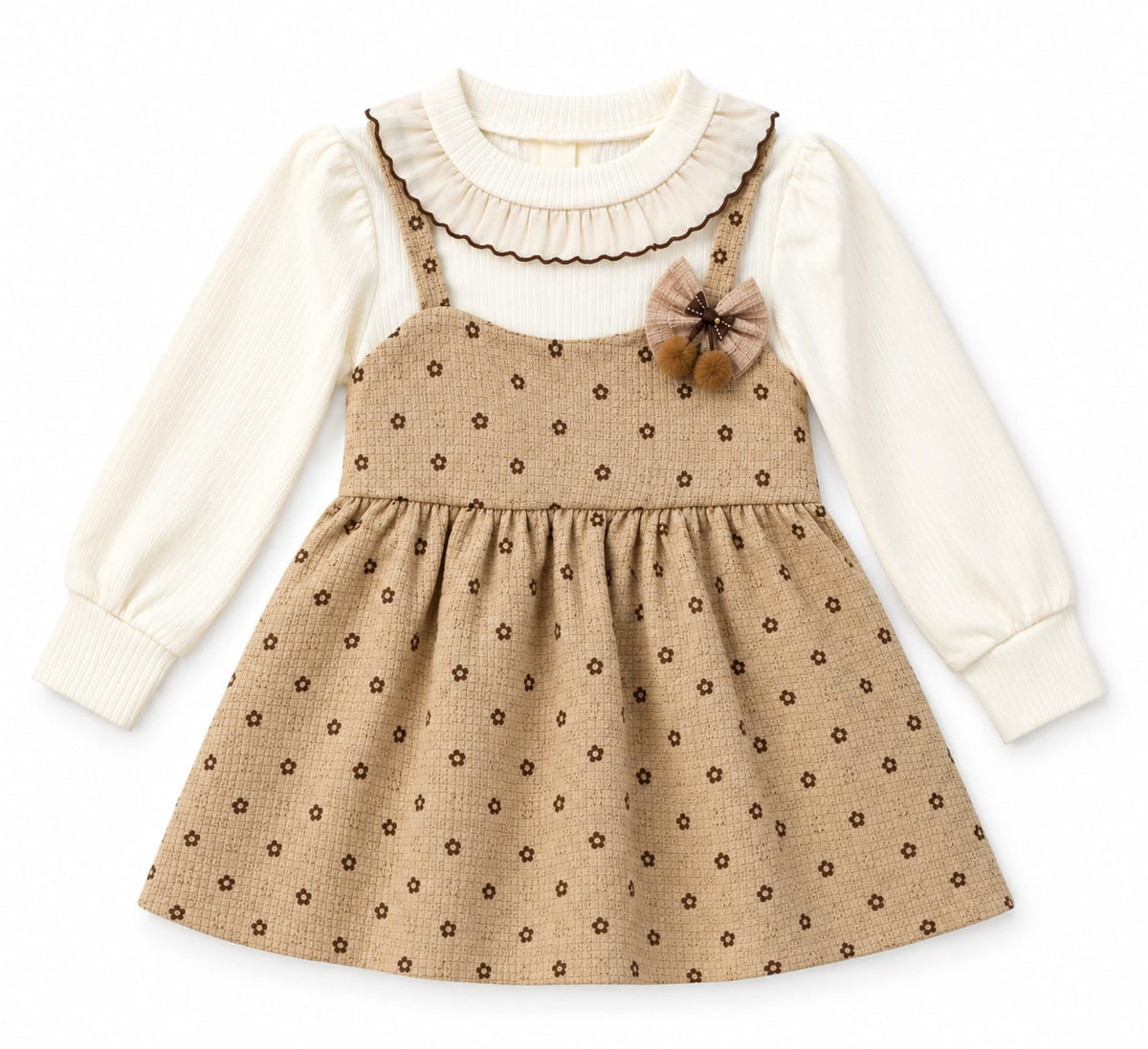 A toddler girl's long-sleeve dress featuring a cream ribbed knit top layer with a ruffled collar and a tan waffle-knit pinafore skirt with small brown floral prints. The skirt has a matching ruffle trim, a gathered waist, and a brown fabric flower accent on the chest.
